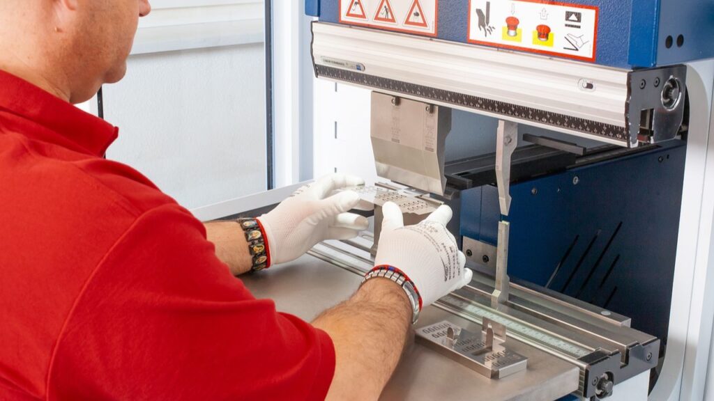 Präzises CNC-Biegen bei SLT – Edwin Schmitt Lasertechnik Ein Mitarbeiter der Edwin Schmitt Lasertechnik GmbH positioniert ein Metallteil zum präzisen CNC-Biegen an der Abkantpresse.